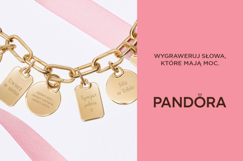 Otwarcie salonu Pandora w Galerii Solnej – złota bransoletka z grawerowanymi zawieszkami z inspirującymi hasłami na różowym tle, promująca personalizowaną biżuterię.