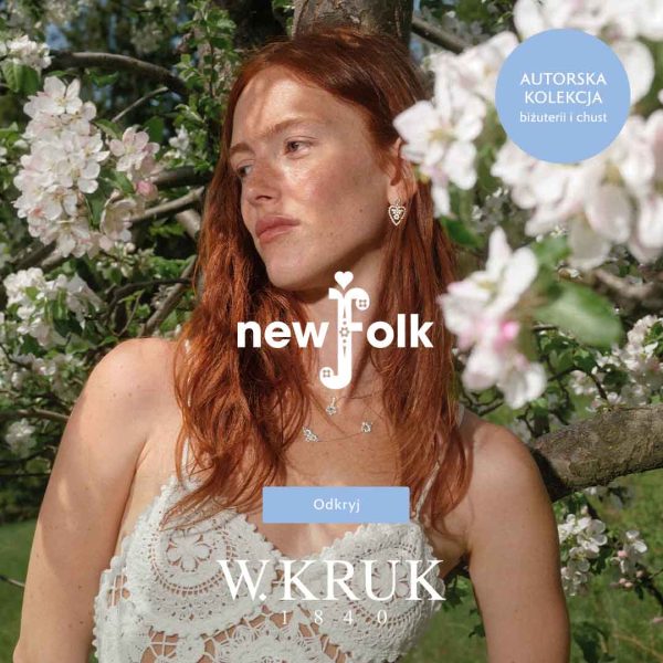 Baner reklamowy marki W.KRUK prezentujący kolekcję „new folk”. Zdjęcie przedstawia rudowłosą kobietę w białej, ażurowej top-sukience z dzianiny, stojącą na tle kwitnących na biało drzew owocowych. Kobieta ma na sobie subtelną biżuterię: kolczyk w kształcie serca oraz delikatny naszyjnik. W centrum grafiki nałożono białe logo kolekcji „new folk” z ozdobną literą f oraz duże logo „W.KRUK 1840”. W prawym górnym rogu znajduje się jasnoniebieskie koło z napisem „AUTORSKA KOLEKCJA biżuterii i chust”, a na środku u dołu umieszczono jasnoniebieski przycisk „Odkryj”.
