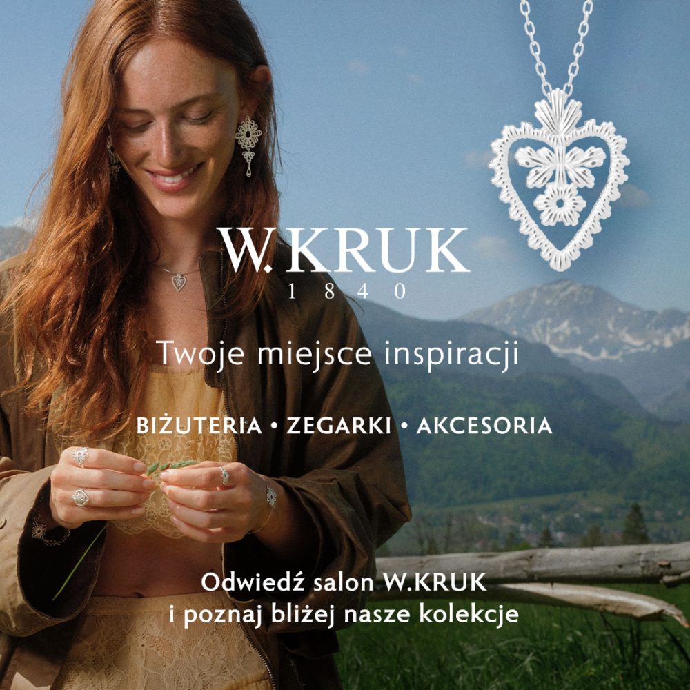 Baner wizerunkowy marki W.KRUK na tle górskiego krajobrazu, przedstawiający uśmiechniętą rudowłosą kobietę w brązowej kurtce i koronkowym topie, ubraną w misternie zdobioną srebrną biżuterię – wiszące kolczyki, pierścionki oraz bransoletkę. W prawym górnym rogu umieszczono powiększenie srebrnego wisiora w kształcie serca z ażurowym wzorem. Na środku widnieje białe logo „W.KRUK 1840”, hasło „Twoje miejsce inspiracji”, pod nim „BIŻUTERIA • ZEGARKI • AKCESORIA” oraz zachęta: „Odwiedź salon W.KRUK i poznaj bliżej nasze kolekcje”.