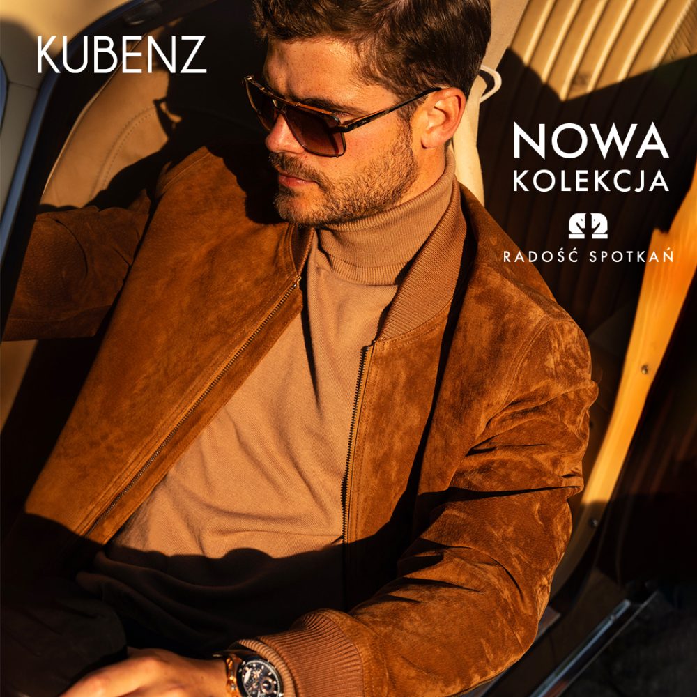 Baner promocyjny marki KUBENZ przedstawiający mężczyznę siedzącego w samochodzie, ubranego w brązową zamszową kurtkę bomberkę, beżowy golf oraz okulary przeciwsłoneczne. W lewym górnym rogu widnieje białe logo „KUBENZ”, a w prawym górnym rogu biały napis „NOWA KOLEKCJA” oraz hasło „RADOŚĆ SPOTKAŃ”.