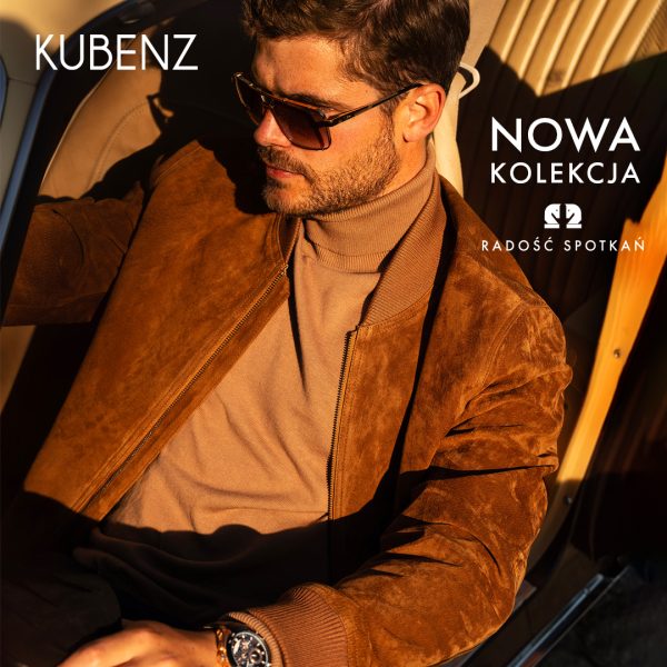 Baner promocyjny marki KUBENZ przedstawiający mężczyznę siedzącego w samochodzie, ubranego w brązową zamszową kurtkę bomberkę, beżowy golf oraz okulary przeciwsłoneczne. W lewym górnym rogu widnieje białe logo „KUBENZ”, a w prawym górnym rogu biały napis „NOWA KOLEKCJA” oraz hasło „RADOŚĆ SPOTKAŃ”.