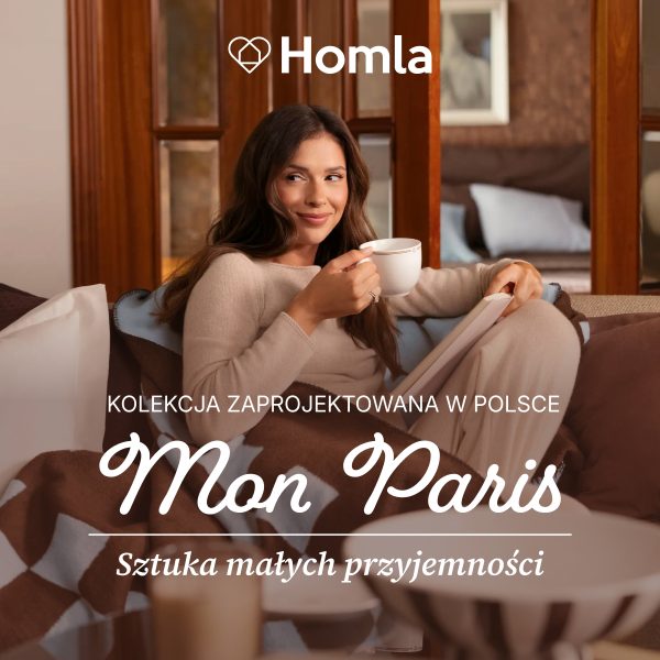 Baner wizerunkowy marki Homla w przytulnym wnętrzu, przedstawiający uśmiechniętą kobietę siedzącą na kanapie w jasnym swetrze, przykrytą brązowo-błękitnym kocykiem we wzory, trzymającą filiżankę oraz otwartą książkę. U góry umieszczono białe logo „Homla”, a na dole napis „KOLEKCJA ZAPROJEKTOWANA W POLSCE”, dekoracyjny nagłówek „Mon Paris” oraz hasło „Sztuka małych przyjemności”.